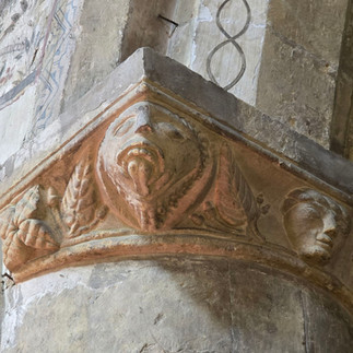 Carved stone capital in inside the church showing a face.