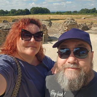A picture of Lise and Bob. It is a selfie and they are both wearing sunglasses. The ruins can be seen behind them.