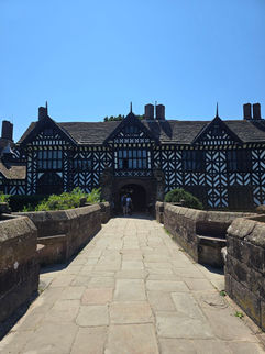 The Tudor manor house at Speke Hall across a stone bridge.