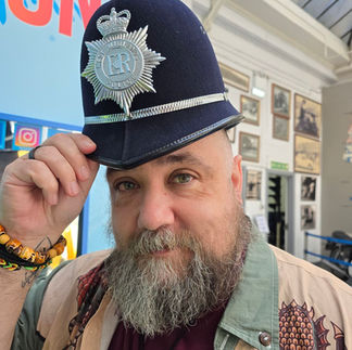 Bob dressing up with a traditional british police hat.