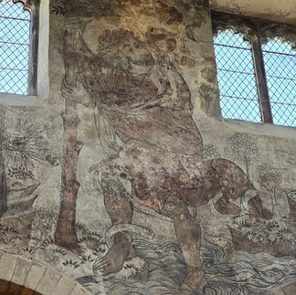 Medieval wall painting of Saint Christopher inside the church.