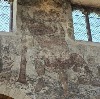 Medieval wall painting of Saint Christopher inside the church.