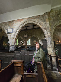 Bob looking around the church stood in between the box pews.