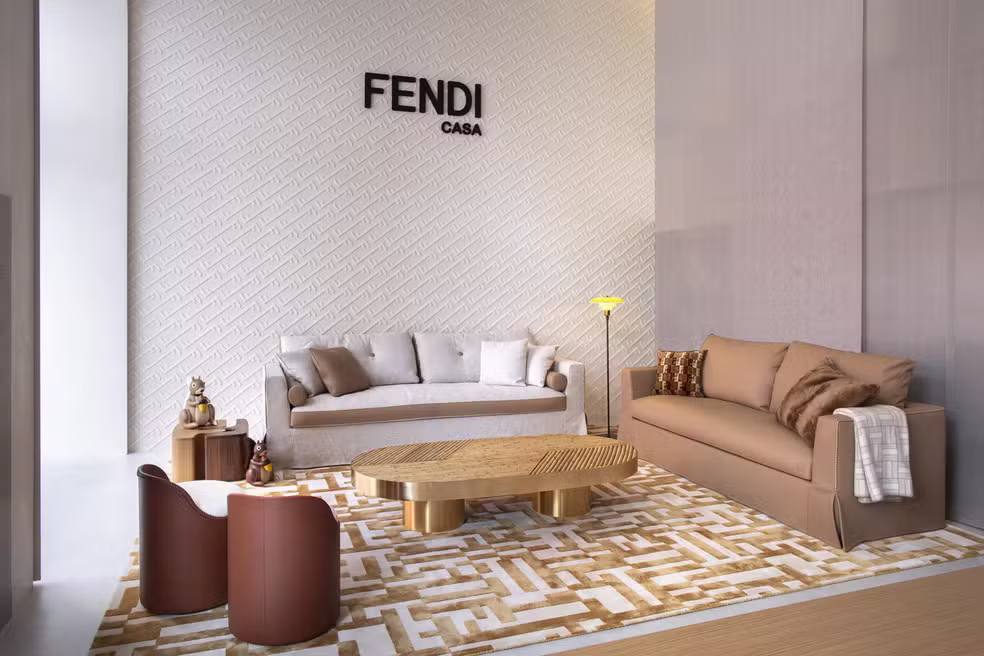 Sala de estar sofisticada da Fendi Casa com sofás em tons neutros, tapete com padrão gráfico e móveis de linhas contemporâneas.