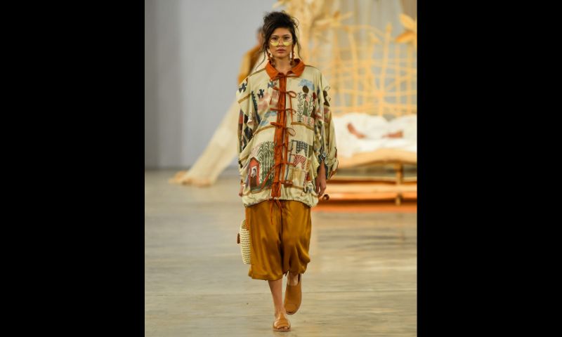 Modelo desfila em passarela da Foz Inverno 2025 com conjunto em tons terrosos