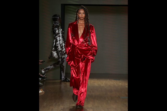 A modelo usa macacão vermelho brilhante