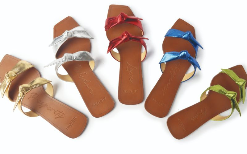 Chapéu de palha em tom amarelo queimado, com aba larga e uma faixa decorativa marrom com pequenos detalhes em forma de cruz. O design combina estilo rústico e elegância, ideal para ocasiões ao ar livre. Fundo branco que destaca os detalhes da peça.