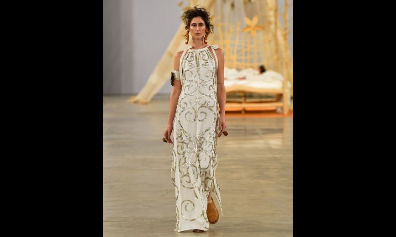 modelo desfila usando vestido branco com detalhes em dourado