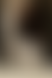 ovem com camiseta preta básica e calça de alfaiataria clara, carregando uma bolsa de ombro bege. Um exemplo discreto e contemporâneo do quiet luxury.