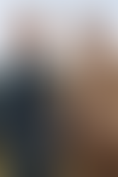 Dois modelos, um vestindo uma jaqueta jeans verde militar e outro usando um conjunto bege de algodão com camisa e calça de alfaiataria.