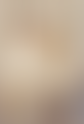 omem e mulher caminhando de mãos dadas em uma rua urbana, ambos vestindo roupas minimalistas e em tons claros, representando o estilo quiet luxury.