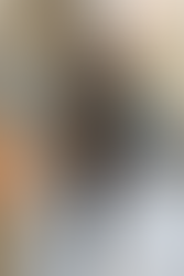 Modelo em um casaco oversized jeans com bordados dourados e detalhes de pele marrom, meias pretas, botas de cano alto e touca preta, com um visual casual e sofisticado.