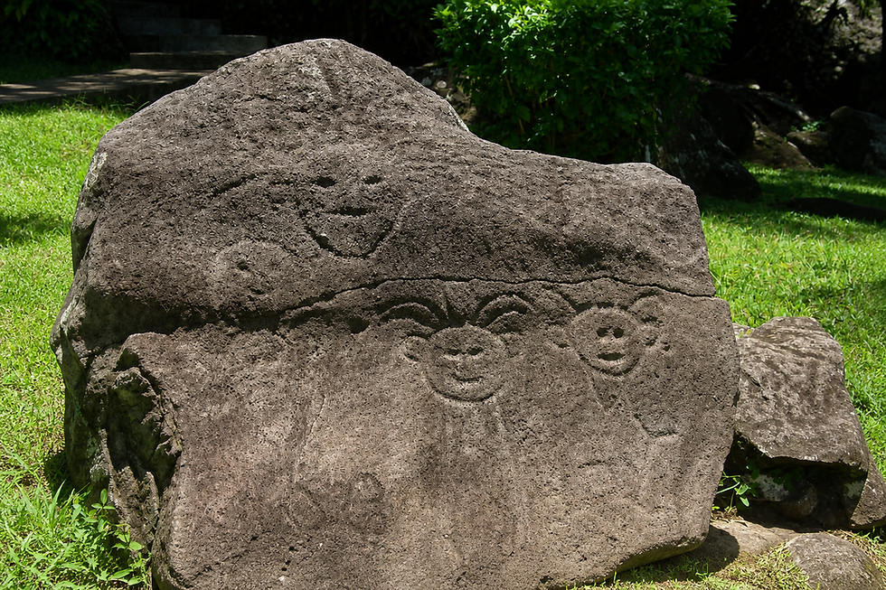 Ancient carved faces with radiating arcs on a volcanic boulder at the Archaeological Park of the Engraved Rocks, Trois-Rivieres, Guadeloupe.