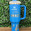 Thumbnail: Stanley Quencher in Azure featuring a custom laser-engraved Charger design, personalized tumbler by KLM Craft Front
