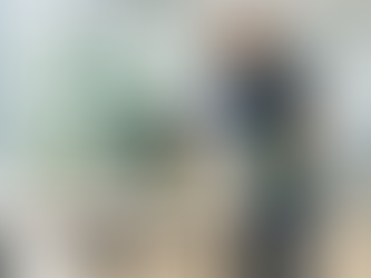 Reinigungskraft der DGS Services GmbH wischt Schreibtisch mit Mikrofasertuch in hellem Büro – allergikerfreundliche Reinigung ohne Duftstoffe.