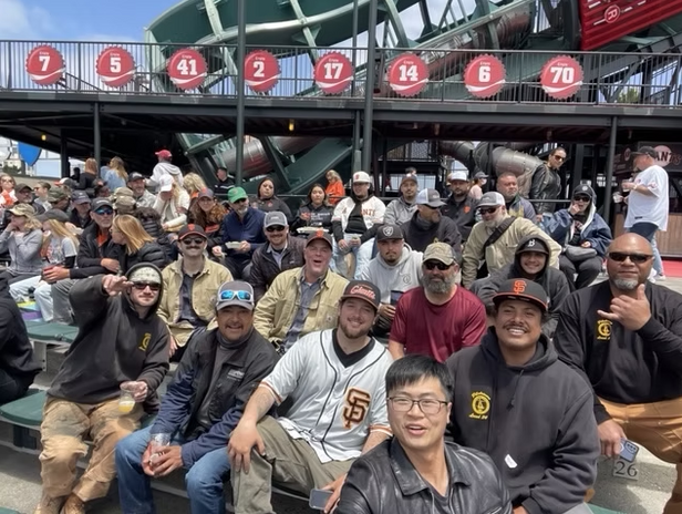 CityBuild graduate, Vincent Liang, with large group of friends watching baseball game
