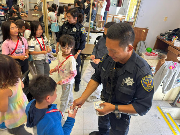 SFPD officer giving stickers to CCSC youth
