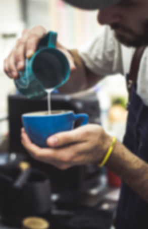Barisa pouring a heart latte art pattern in cappuccino in Bloom Coffee Belgrade.