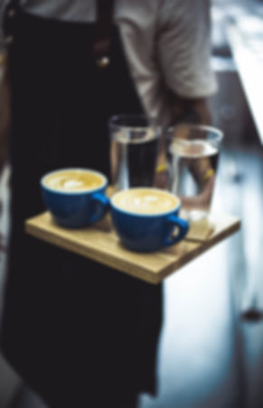 Barista servng two cappuccinos in Bloom Coffe Begrade.