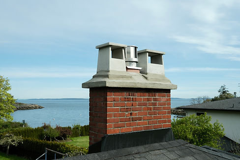 A brick chimney that has been repointed and capped by Lennox Masonry