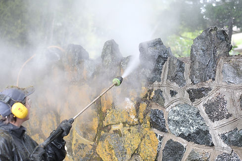 A heritage stone wall in Rockland, Victoria BC being steam cleaned by employees of Lennox Masonry