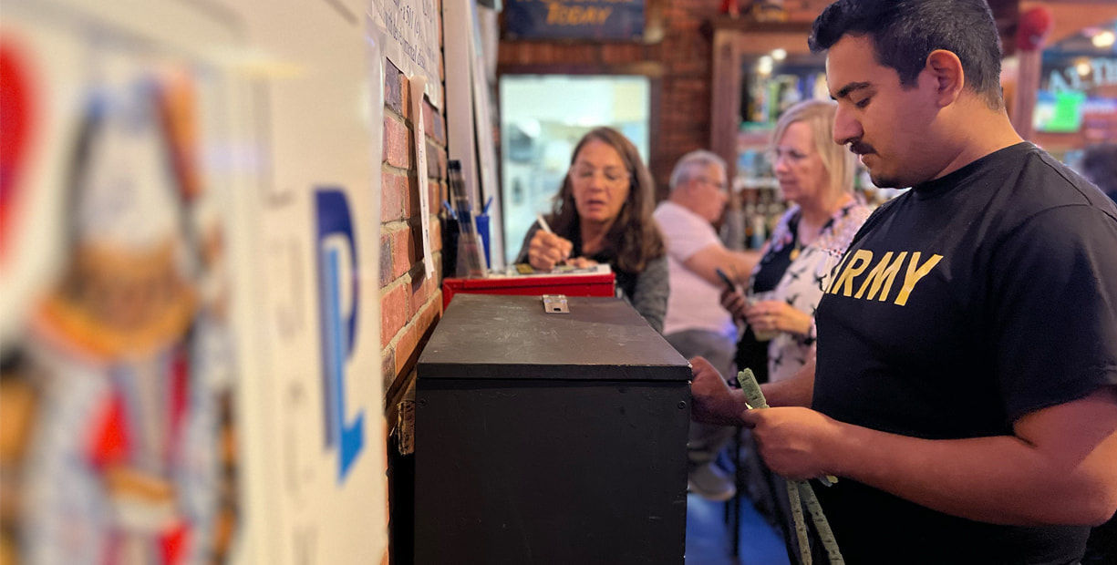 Man and others by a counter.
