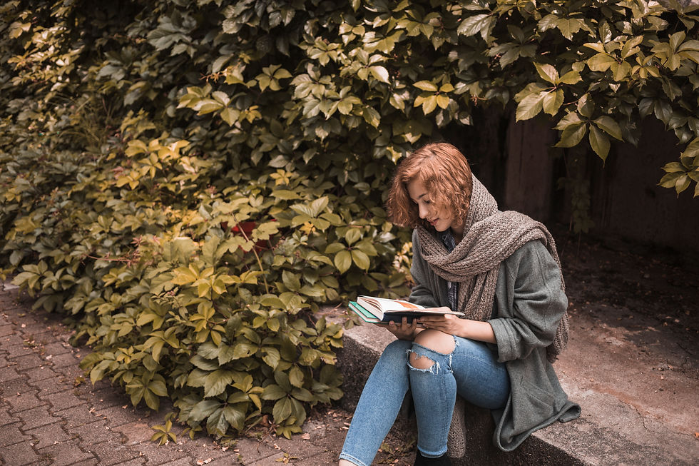woman-street-wear-sitting-board-reading-book-near-plant.jpg