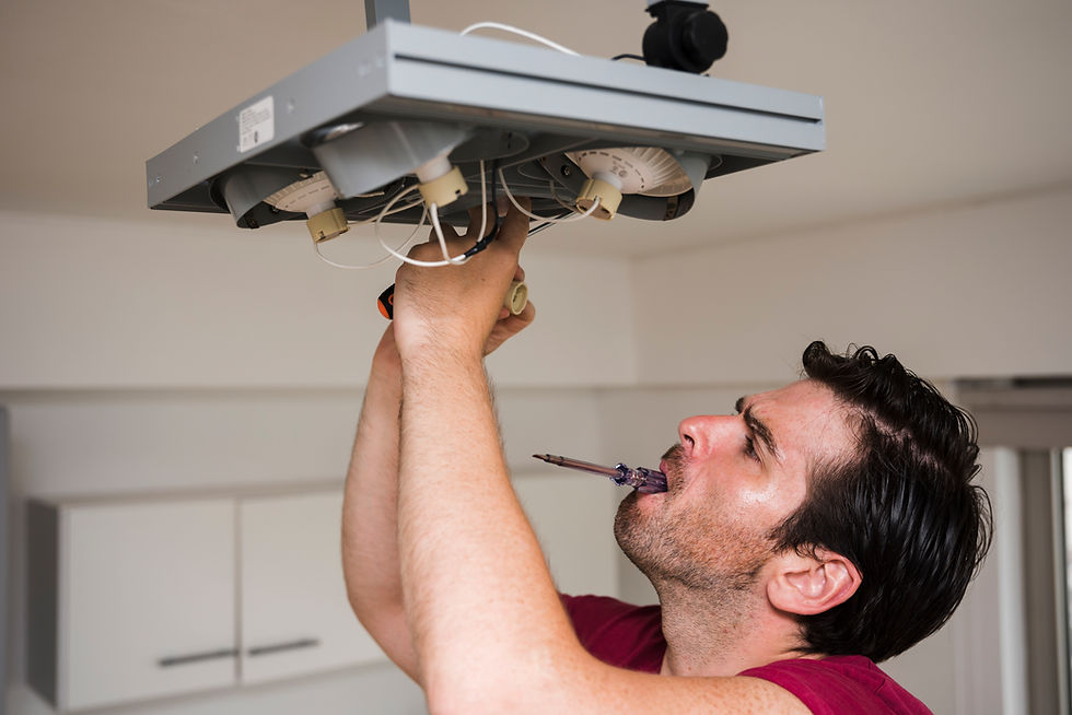 Technician maintaining ceiling light fixture