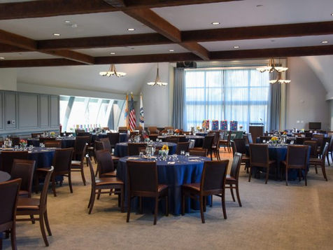 Dining room set with navy linens under exposed beams at The Clubhouse at Hominy Hill, Colts Neck NJ