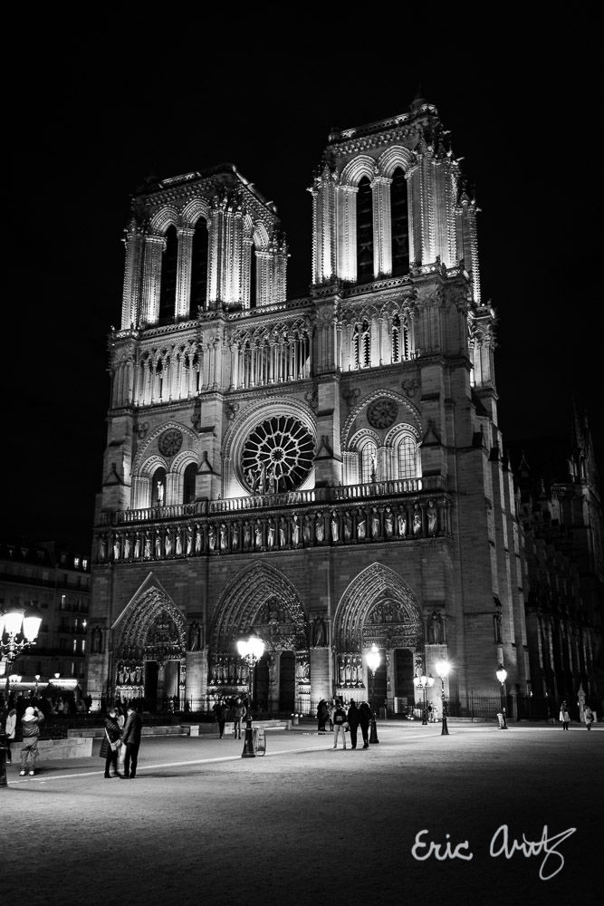 A black and white photo of Notre-Dame de Paris lit up at night