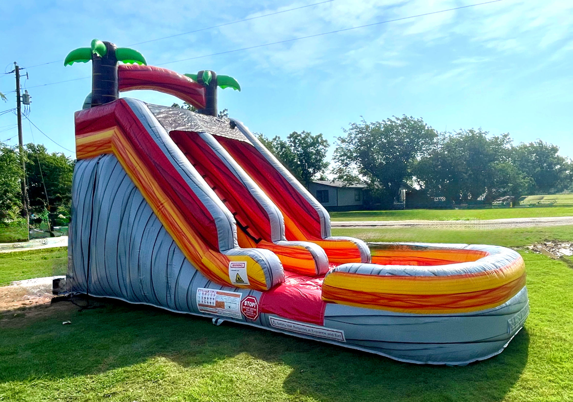 15 foot high volcano themed slide with a pool on the end and palm trees on the top. Red slides.
