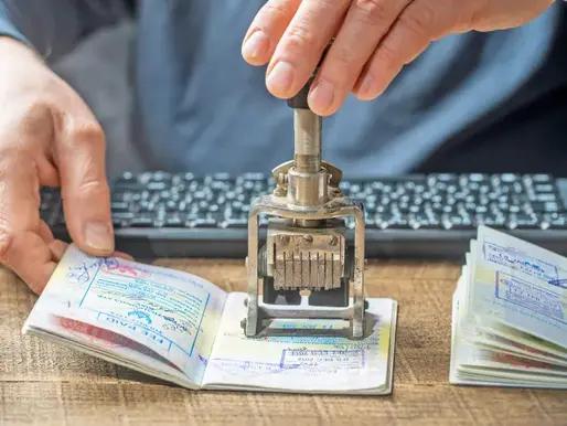 A person is stamping a passport during entry/exit