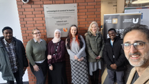 A group of people posing by the School of Science and Engineering sign at Teesside University