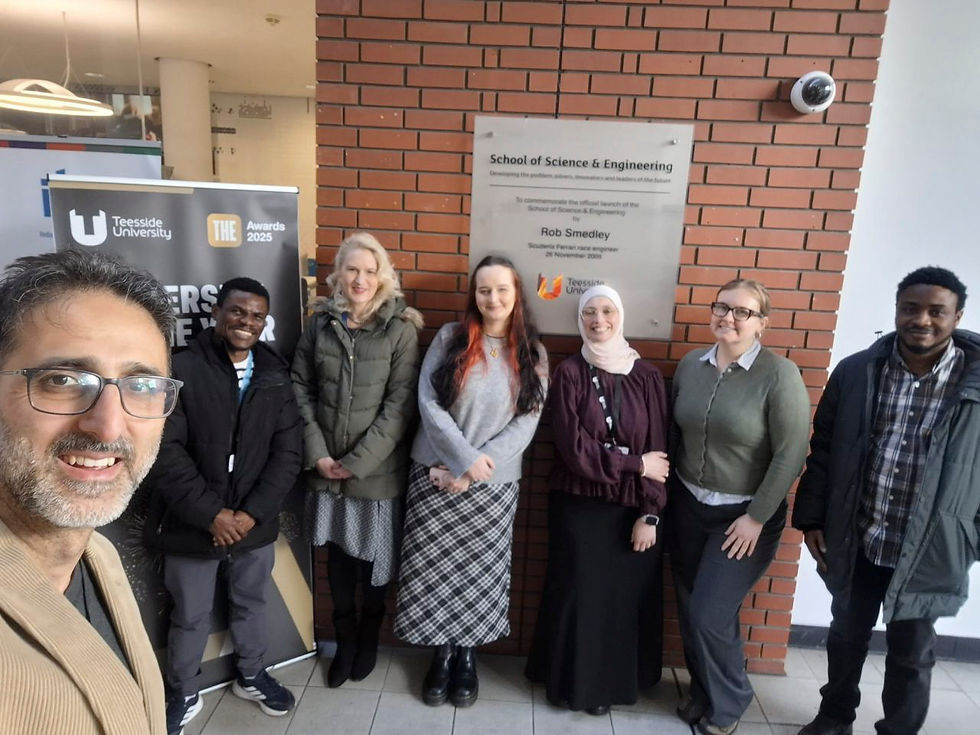 A group of people posing by the School of Science and Engineering sign at Teesside University