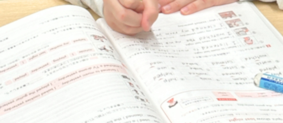 小学生がドリルに集中して取り組む様子（寝屋川市の英語教室）