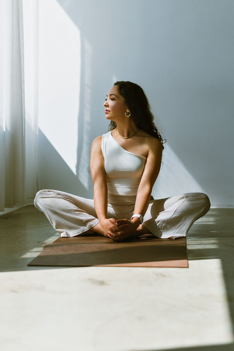 Mulher sentada em postura de meditação nas aulas e práticas de yoga.