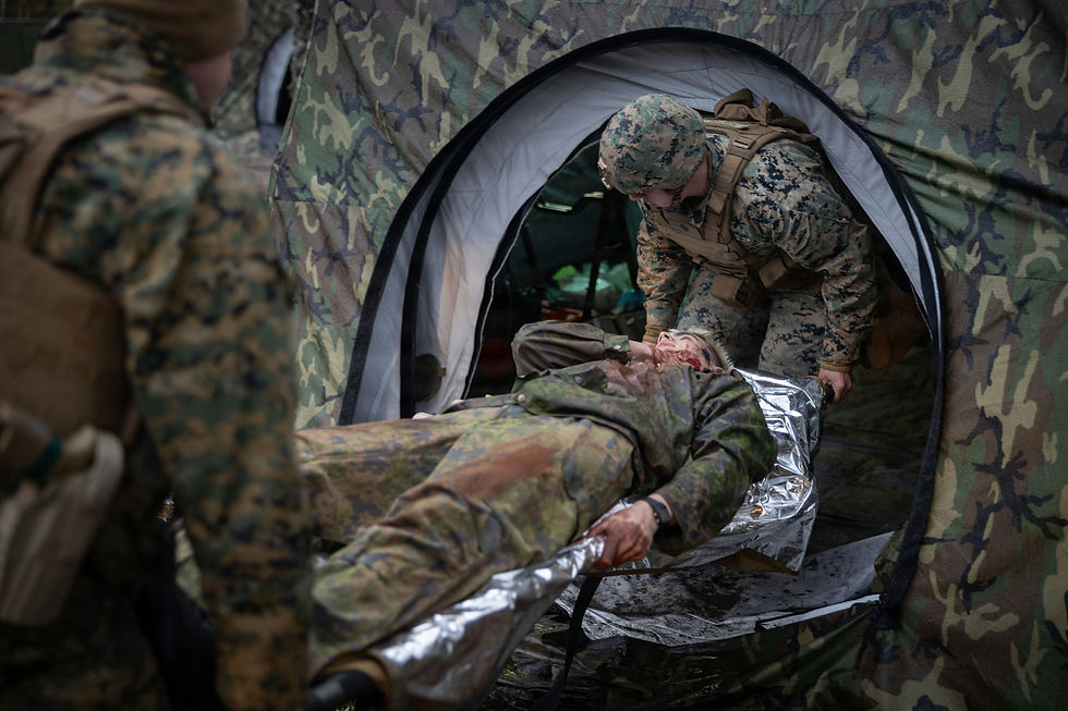Soldiers in camo gear carry an injured comrade on a stretcher out of a camo tent. The scene is tense and urgent, with muted colors.