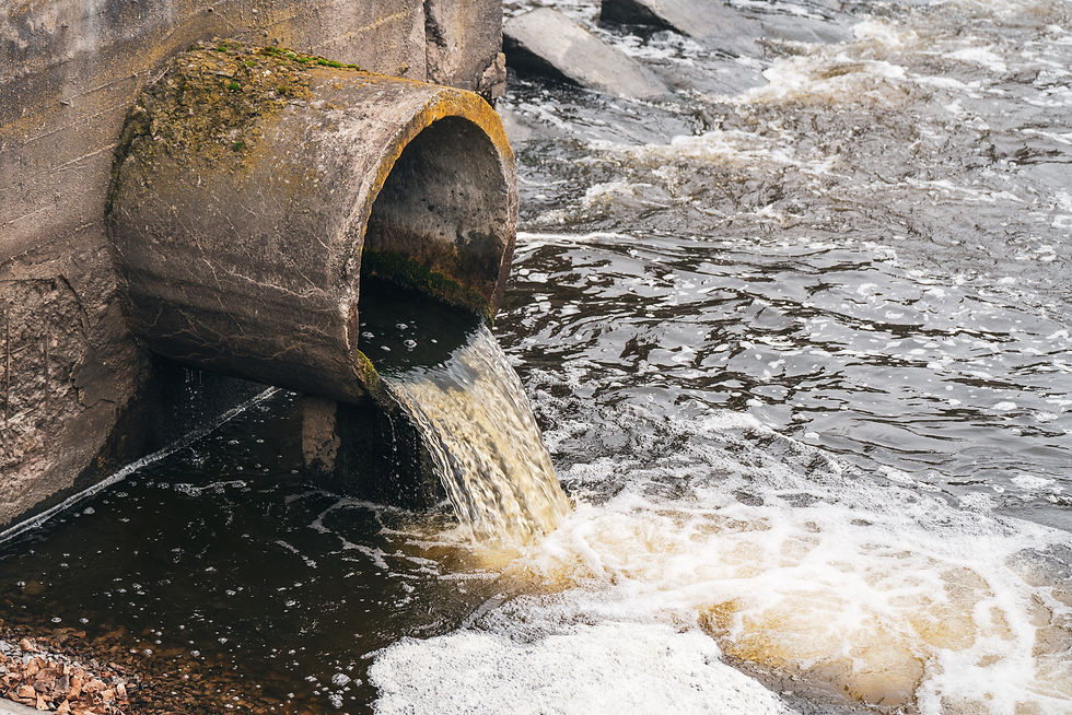 Concrete pipe discharging water into a flowing river or stream. The water appears turbulent at the outlet