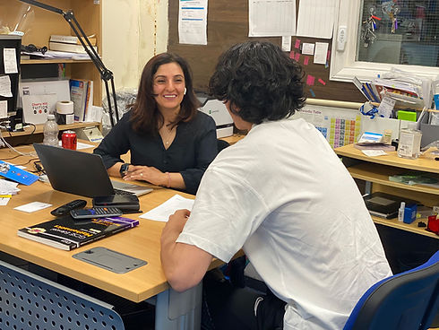 a person sitting at a desk with a laptop and a person sitting at a desk