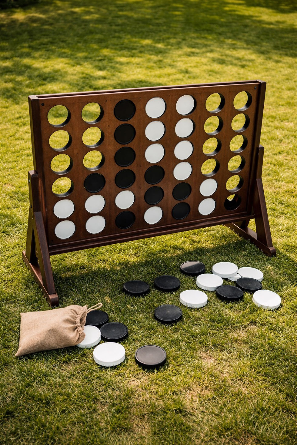 Wooden ring toss game with colored pegs on a sunny lawn, blurred garden and house in the background, evoking a playful summer mood.