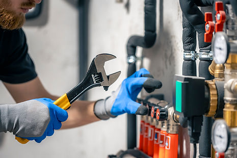 man-installs-heating-system-house-checks-pipes-with-wrench.jpg