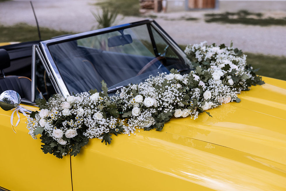 Vintage Hochzeitsauto in Gelb, dekoriert mit weißen Blumen