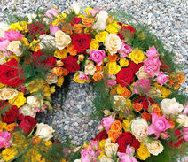 Farbenfroher Trauerkranz mit Rosen und saisonalen Blüten, lebendig gestaltet