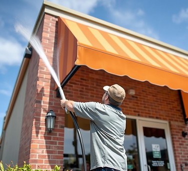 man pressure washing business awning.jpg