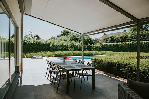 Moderne pergola met elektrische doekzonwering voor terras, gerealiseerd door Zonwering-winkel.