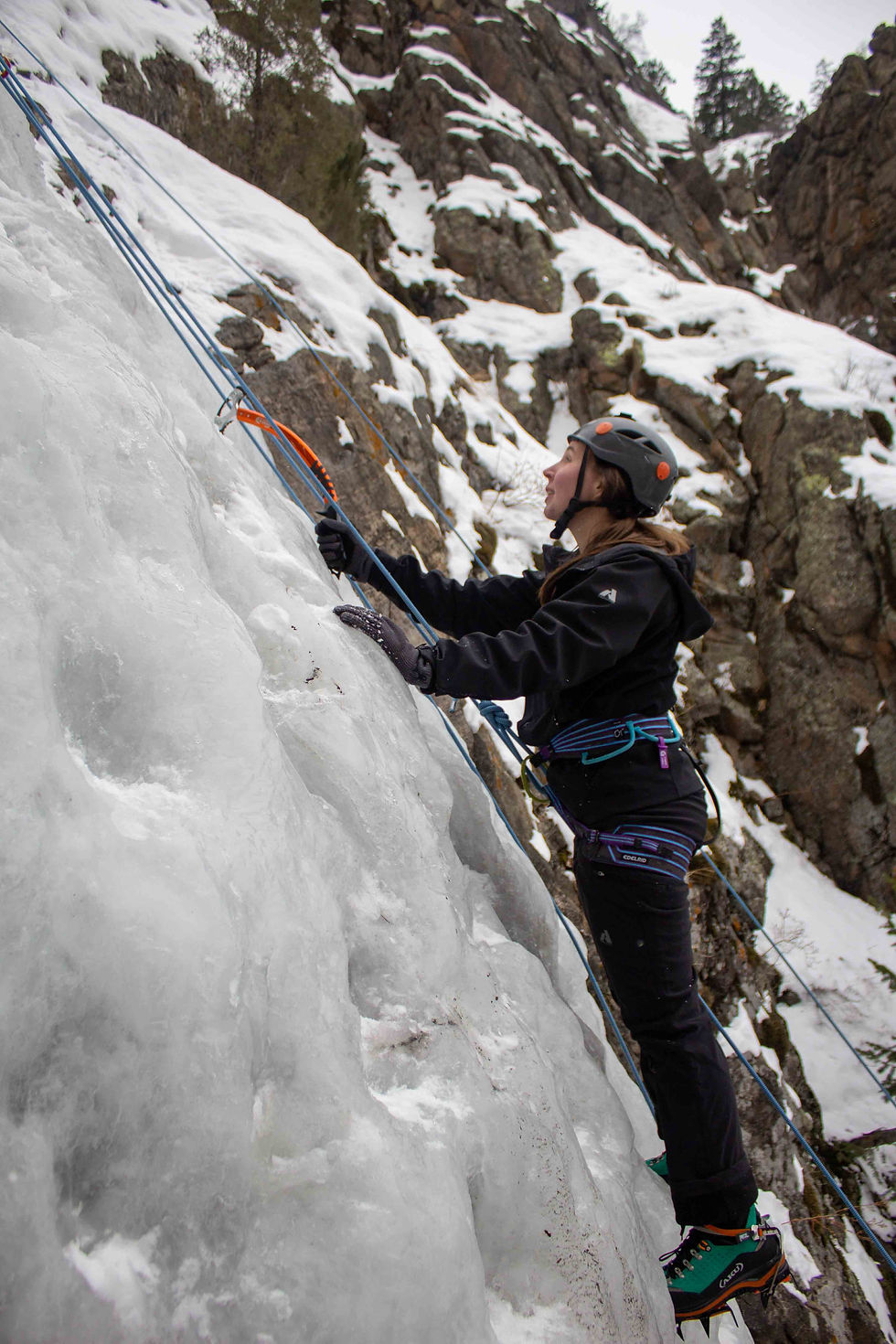 Ice climber with one ice tool climbing frozen waterfall