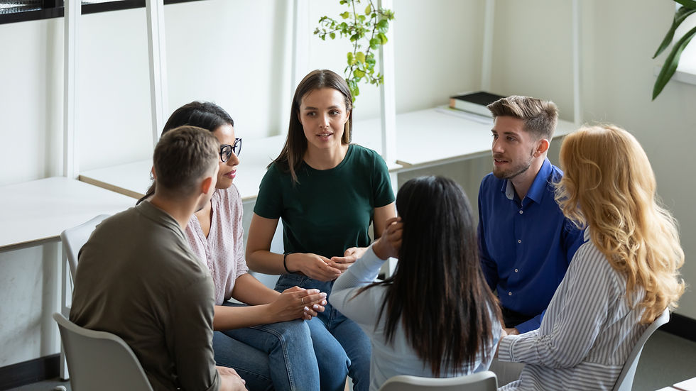 group of young people sits in a circle, engaged in conversation and laughter