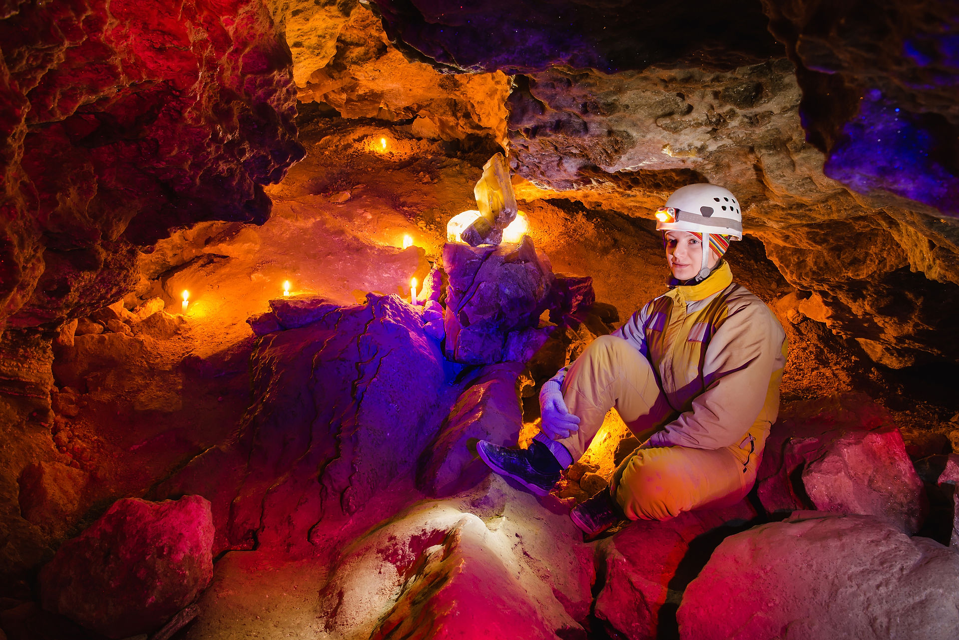 Redcliffe Caves illuminated by candlelight, casting warm glows and flickering shadows in the underground chambers
