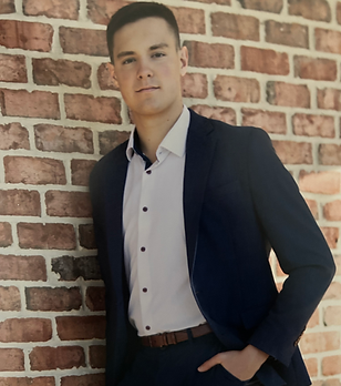 Gregg, SAT prep coach at AceSATCoach, wearing a navy blazer and white dress shirt, standing against a brick wall