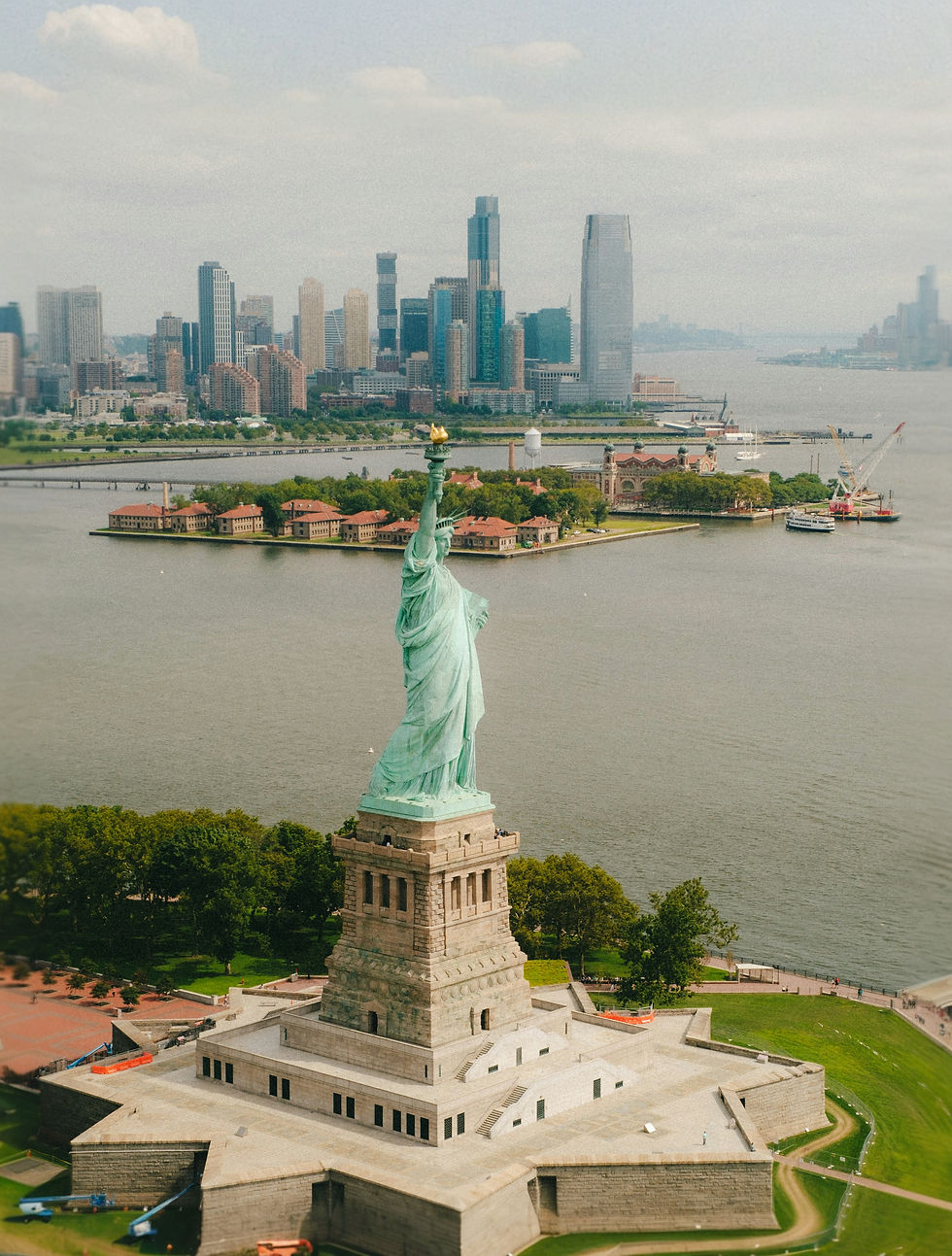 large statue on an island and city in background
